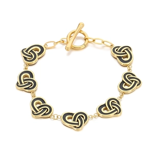 Gold chain bracelet with black enamel heart links and toggle clasp on white background