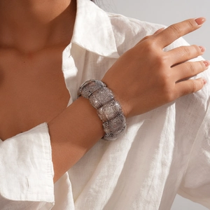 Detail eines breiten Ethno-Stretch-Armbands mit glitzernder Oberfläche und Textur