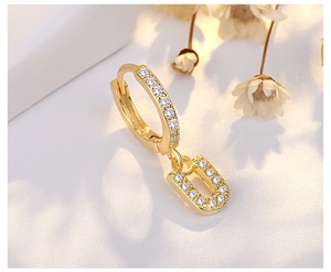 Detail of gold U-shaped earring featuring micro-pave cubic zirconia on a minimalist hoop