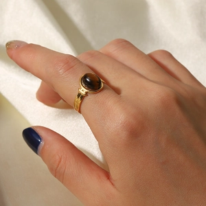 Vue détaillée d'une bague ovale en œil de tigre plaquée or 18 carats portée sur soie