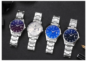 Detail view of four stainless steel watches with colorful dials and calendar display feature