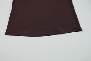 Detailed close-up of double-stitched hem on a dark brown knit one-shoulder dress