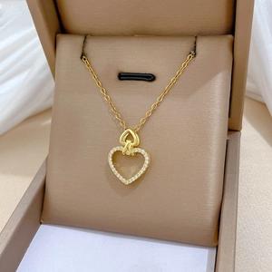 Macro close-up of golden double heart pendant necklace with shimmering zircon stones