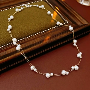 Vue détaillée du collier de perles double épaisseur sur cadre avec chaîne dorée