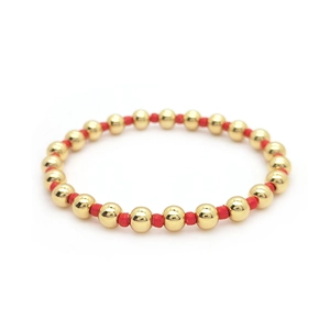 Minimalist 18K gold and red beaded elastic bracelet with polished metallic finish
