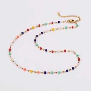Close-up of golden necklace with colorful square beads and lobster clasp detail