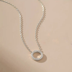 Elegant silver circular pendant necklace with shimmering pave zircons on minimalist chain