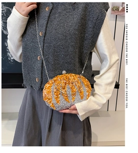 Detail of beaded pumpkin evening clutch bag with sparkling crystals and silver chain