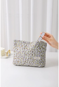 Lippenstift in floralen Jacquard-Kulturbeutel mit grün-violettem Blumenmuster legen