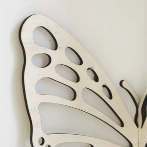 Detail of laser-cut hollow butterfly wing wooden shelf with natural plywood texture