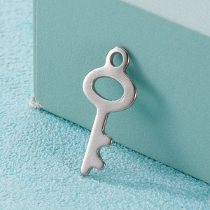 Minimalist silver stainless steel key pendant accessory for jewelry making on blue surface
