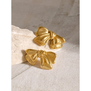 Brushed 18k gold stainless steel bow earrings on a natural stone background