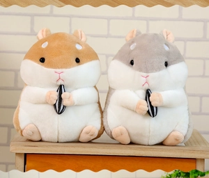 Detail of plush hamster keychains in brown and grey holding striped seeds on wood