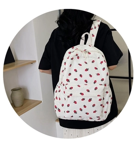Corduroy strawberry backpack shown from the back perspective on a model at home