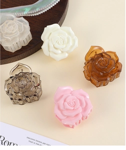 Détail de pinces à cheveux rose 3D en cinq couleurs sur fond neutre et chaleureux