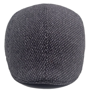 Close-up of grey tweed fabric texture and durable stitching on a men's winter flat cap