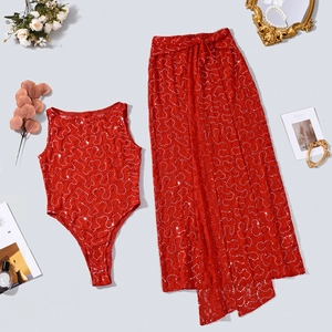 Detailed macro view of red sequin lace bodysuit and wrap skirt with heart pattern texture