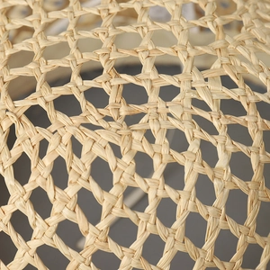 Close-up of a women's summer raffia sun hat featuring a hollow star-shaped weave pattern