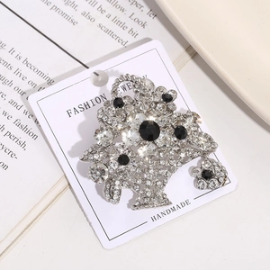 Macro shot of silver flower basket brooch with black and white crystals on display card