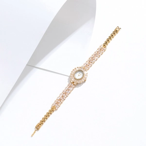 Detailed close-up of a gold women's watch featuring a crystal-encrusted band and bezel