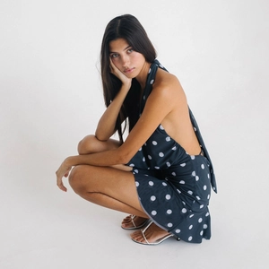 Robe dos nu à pois bleu marine montrant les détails de l'ourlet irrégulier du vêtement