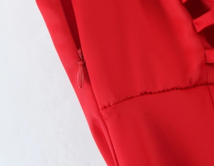 Detail of invisible side zipper and lacing structure on this red fishtail evening gown
