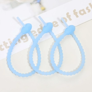Close-up of three light blue flexible silicone cable ties with non-slip gear design