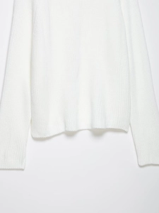 Close-up of white knitted sweater featuring textured vertical knit and smooth hem detail