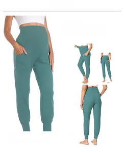Detail of high waist maternity yoga pants in sage green with belly support and side pockets