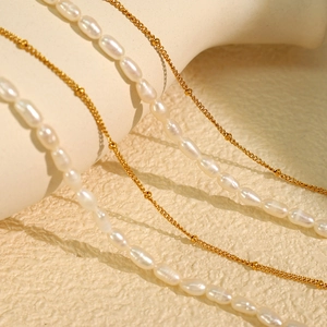 Elegant layered necklace featuring white freshwater pearls and fine gold rose pendant
