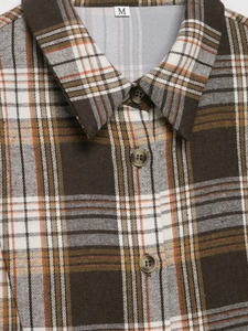 Gros plan du col de chemise à carreaux marron avec boutons ambrés et texture coton