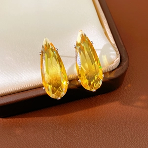 Detailed view of yellow pear-cut cubic zirconia teardrop earrings in claw setting