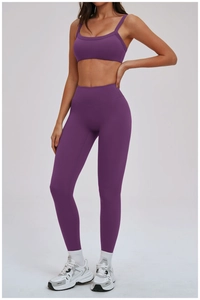 Dettaglio dei leggings viola da yoga con vita a V e tessuto a compressione elastica opaca