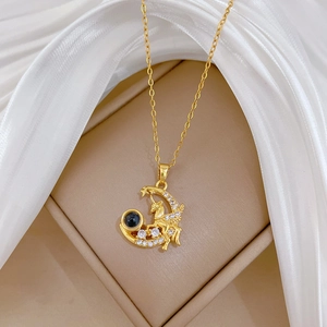 Close-up of golden unicorn moon pendant with sparkling crystals on beige silk jewelry box