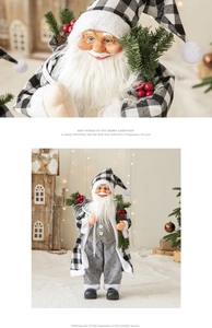Detail of Santa Claus figurine in black and white plaid suit with pine branch and berries
