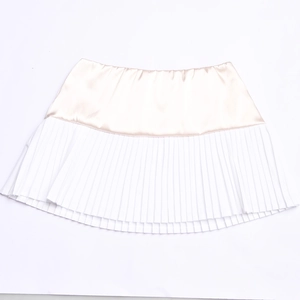 Detailed flat lay of a sexy patchwork pleated skirt with beige satin waist and white hem