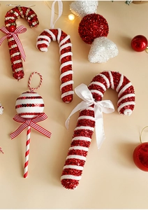 Detail of glittery red and white candy cane ornaments with festive bows for Christmas trees