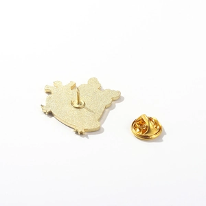 Macro shot of gold-plated Christmas frog pin back showing metal spur and butterfly clutch