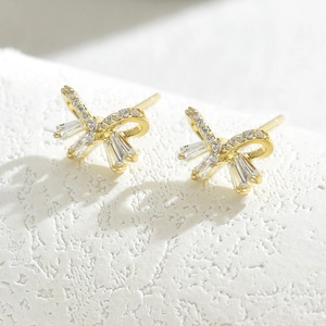 Elegant gold bow earrings with micro-paved zircons and baguette-cut crystal accents