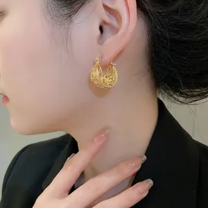 French vintage style gold hollow floral hoop earrings on female model with side view macro