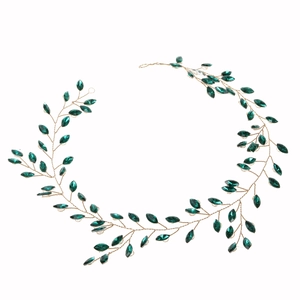 Close-up of marquise emerald rhinestones on a gold wire bridal hair headband