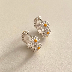 Detailed close-up of S925 sterling silver daisy hoop earrings with white enamel petals