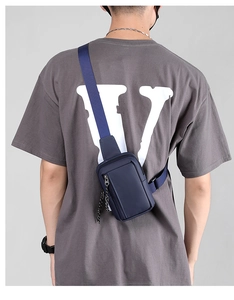 Rear view of a navy blue waterproof nylon chest bag with adjustable strap on a male model