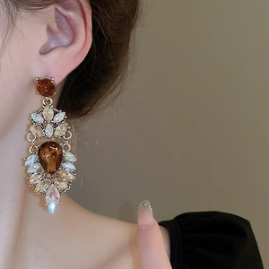 Vintage palace style drop earrings with amber stones and gold flower design on model