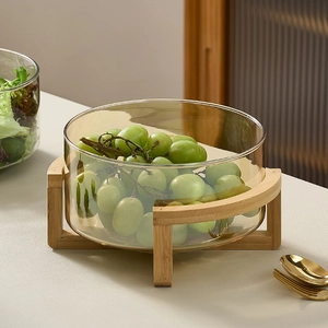 Amber glass salad fruit bowl with a cross wooden stand on a beige countertop