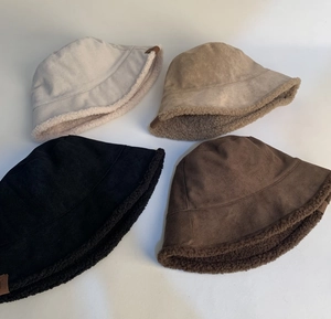 Flat lay of suede and lamb wool fisherman hats in four colors with leather logo detail