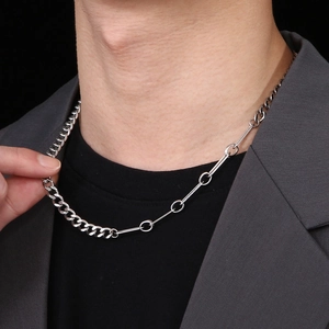 Detail of silver stainless steel Cuban link mixed chain necklace on a blazer