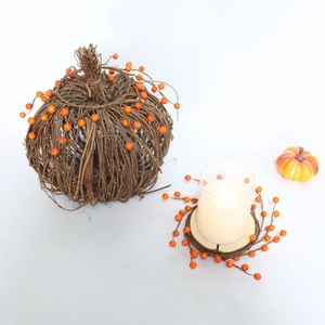Detailansicht des handgefertigten Weidenkürbiskranzes mit Beeren und Glaskerzenhalter für Herbstdeko