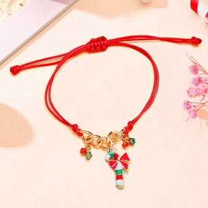 Macro shot of handmade red woven bracelet with a Christmas candy cane pendant detail