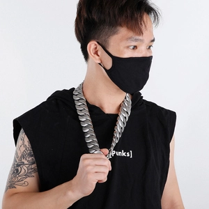 Close-up of a 31mm thick silver stainless steel Cuban link necklace worn by a male model